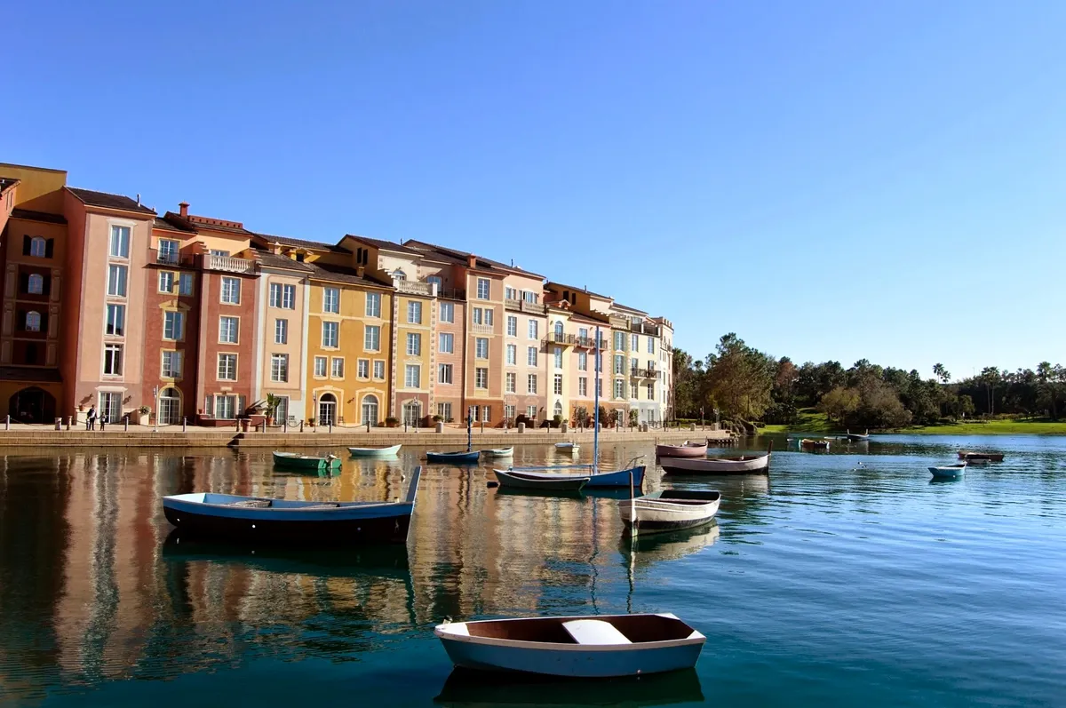Fachadas coloridas do Loews Portofino Bay Hotel, com barcos e reflexos na água.
